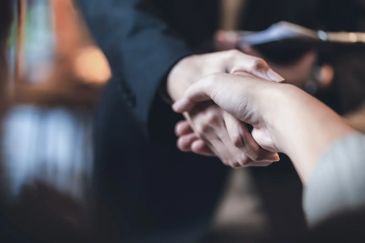 Dos profesionales cerrando un acuerdo con un apret&oacute;n de manos